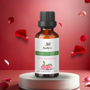 Mezcla de Aceite Esencial de Rosas de Jazlyn Perfumería en frasco de 10 ml , sobre pedestal con delicados pétalos de rosa y fondo degradado, lista para usar en humidificador y aromaterapia relajante