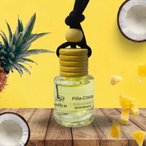 Difusor colgante para auto con aroma a Piña Coco de Jazlyn Perfumería,sobre fondo amarillo brillante con piña y medio coco,ideal para unafragancia tropical y duradera en el auto.